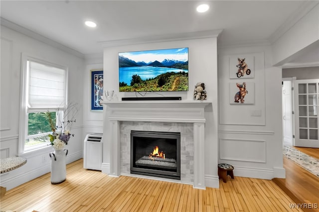 detailed view of ornamental molding, wood finished floors, a tile fireplace, and recessed lighting