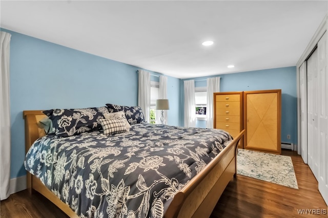 bedroom with baseboard heating, wood finished floors, a closet, and recessed lighting