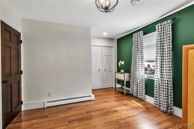 bedroom featuring a baseboard radiator, wood finished floors, recessed lighting, and a closet