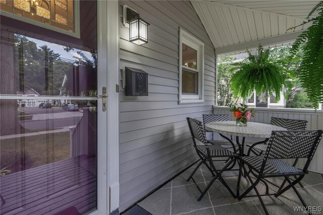 balcony with outdoor dining space and a porch