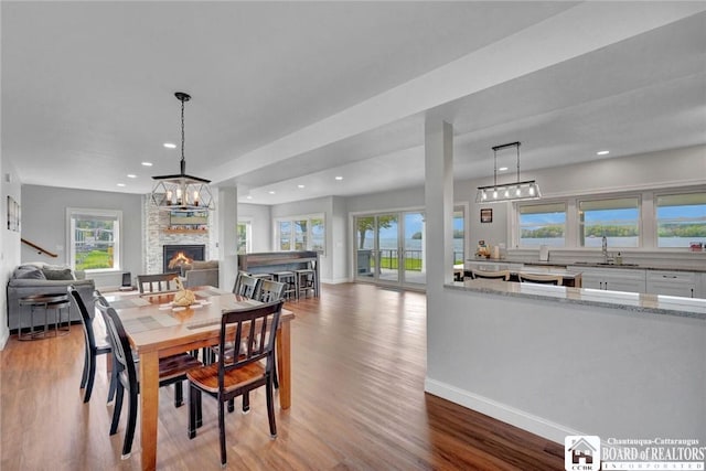 5518 Wells Bay Lakefront, North Harmony, NY 14710 - dining area featuring a fireplace, wood finished floors, recessed lighting, baseboards, and a chandelier