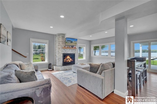 5518 Wells Bay Lakefront, North Harmony, NY 14710 - living room featuring plenty of natural light, a stone fireplace, wood finished floors, and recessed lighting