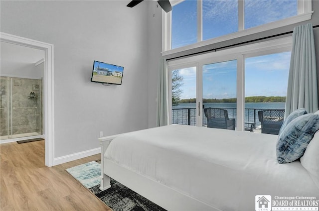 5518 Wells Bay Lakefront, North Harmony, NY 14710 - bedroom with access to outside, baseboards, a towering ceiling, light wood-type flooring, and ensuite bathroom