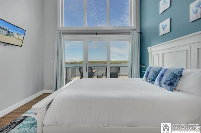 5518 Wells Bay Lakefront, North Harmony, NY 14710 - bedroom featuring access to outside, wood finished floors, a towering ceiling, and baseboards
