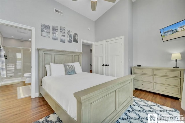 5518 Wells Bay Lakefront, North Harmony, NY 14710 - bedroom featuring a towering ceiling, wood finished floors, ensuite bathroom, a closet, and baseboards