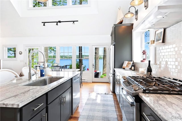 2330 Thornton S, Skaneateles, NY 13152 - kitchen featuring appliances with stainless steel finishes, a sink, light wood finished floors, light stone counters, and under cabinet range hood