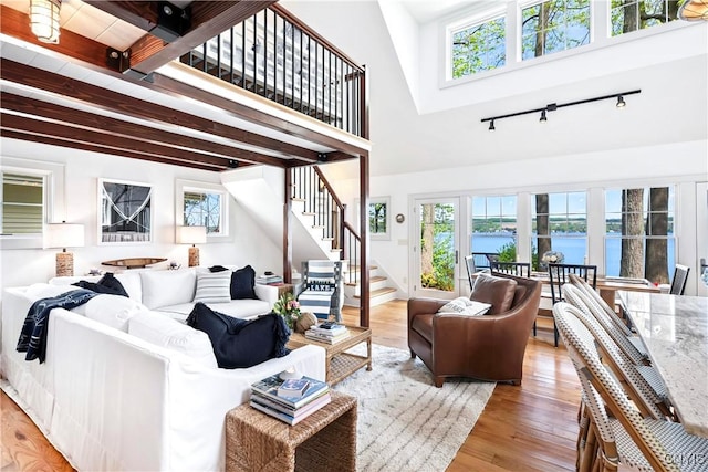 2330 Thornton S, Skaneateles, NY 13152 - living area featuring stairway, rail lighting, light wood-style flooring, a water view, and beam ceiling