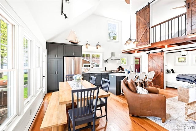 2330 Thornton S, Skaneateles, NY 13152 - dining area featuring a barn door, high vaulted ceiling, and light wood-style flooring