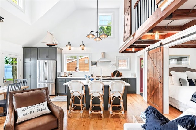 2330 Thornton S, Skaneateles, NY 13152 - dining area with a barn door, high vaulted ceiling, light wood-type flooring, and healthy amount of natural light