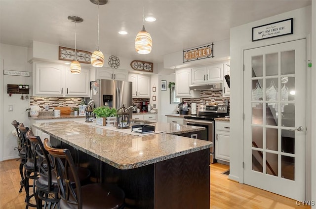 101 Pinehurst Ln, Augusta, NY 13425 - kitchen featuring stainless steel appliances, under cabinet range hood, white cabinets, a breakfast bar area, and light wood finished floors