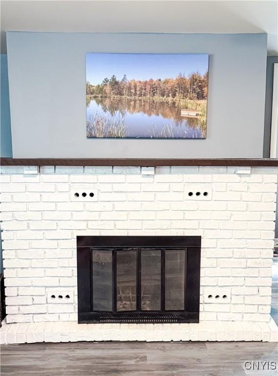 detailed view of a brick fireplace and wood finished floors