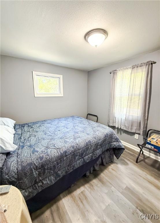 bedroom featuring wood finished floors and baseboards