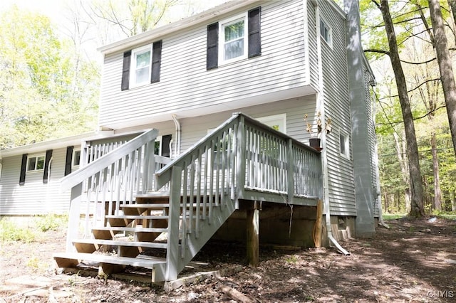 back of house featuring stairway and a wooden deck