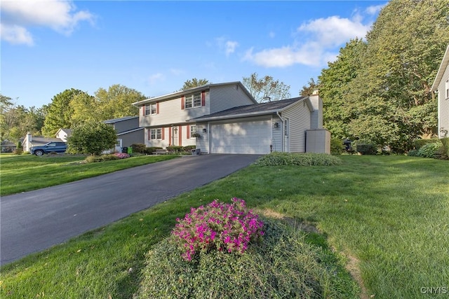 view of front of house featuring a chimney, an attached garage, driveway, and a front lawn