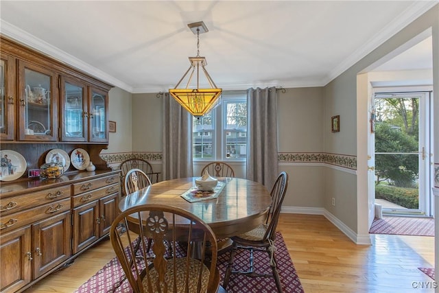 dining space with plenty of natural light, light wood finished floors, ornamental molding, and baseboards