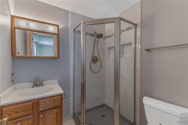 bathroom with a shower stall, toilet, and vanity