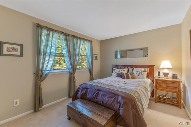 bedroom with light colored carpet and baseboards