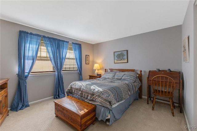 bedroom featuring light carpet and baseboards