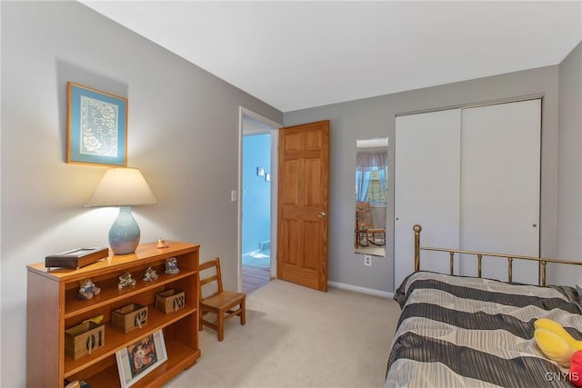 bedroom featuring light colored carpet, a closet, and baseboards