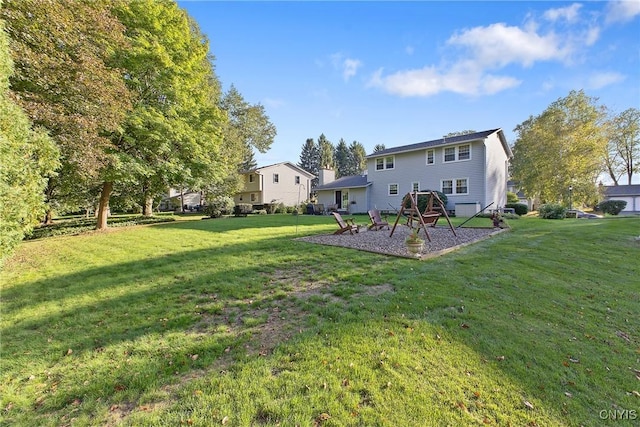 back of house featuring a yard and a playground