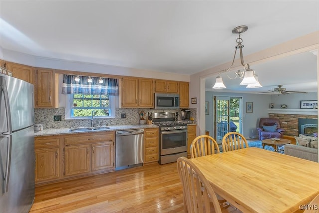kitchen featuring appliances with stainless steel finishes, a sink, plenty of natural light, and light wood finished floors