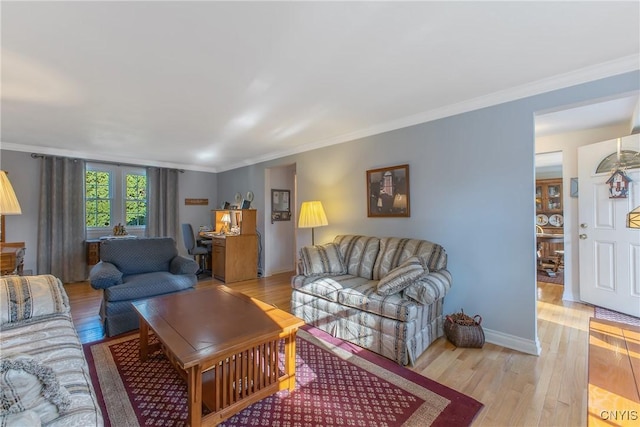 living area featuring light wood-type flooring, crown molding, and baseboards