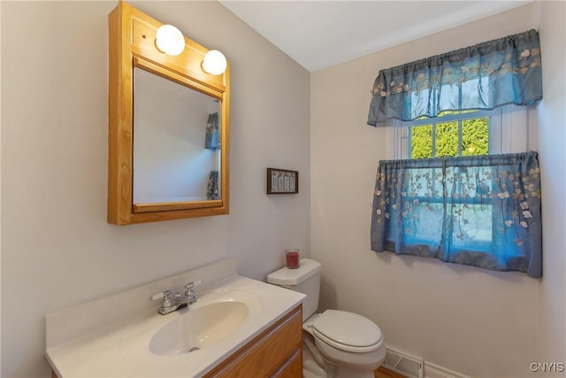 half bathroom with vanity and toilet
