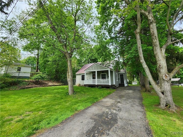 bungalow featuring a porch, driveway, and a front lawn