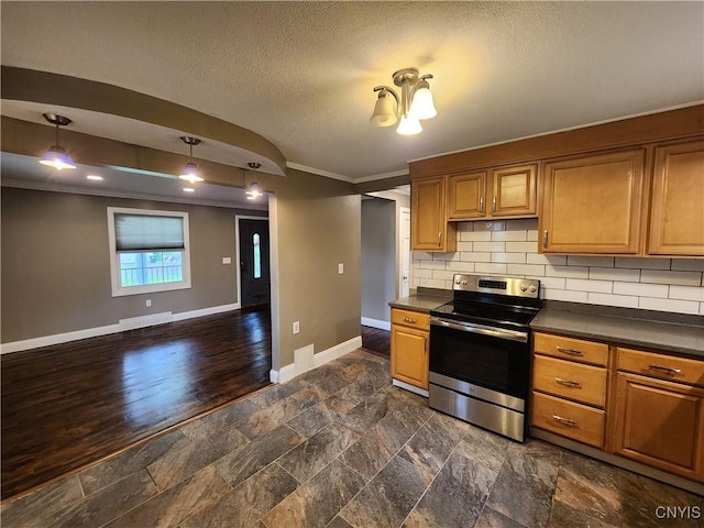 kitchen with stainless steel electric range, dark countertops, crown molding, baseboards, and a textured ceiling