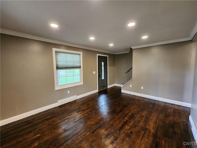empty room featuring crown molding, dark wood-style floors, baseboards, recessed lighting, and stairway
