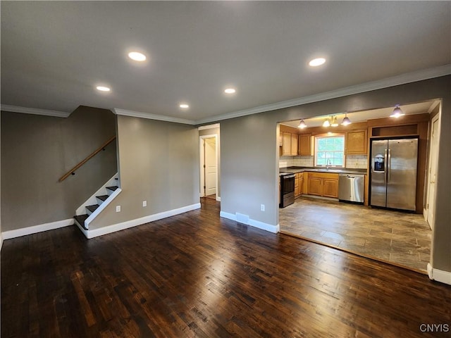 unfurnished living room with ornamental molding, a sink, hardwood / wood-style flooring, stairway, and recessed lighting