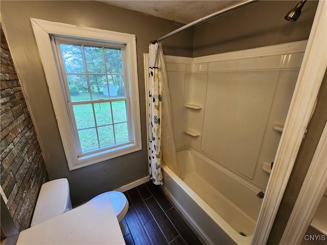 full bath with baseboards, wood finished floors, and shower / bath combo