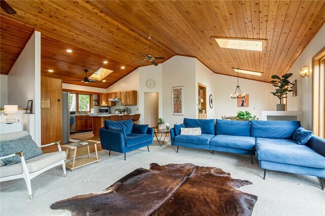 living room featuring light carpet, a skylight, vaulted ceiling, wood ceiling, and ceiling fan