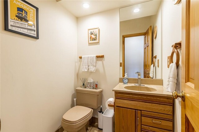 bathroom featuring toilet, vanity, and recessed lighting