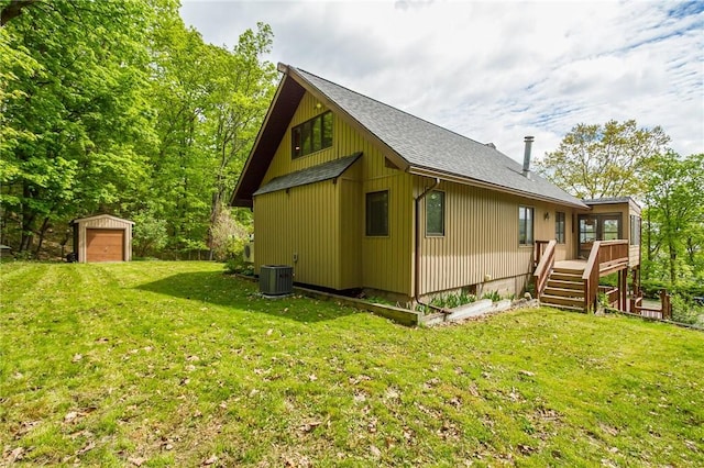 view of property exterior with stairs, an outbuilding, central air condition unit, a shingled roof, and a wooden deck