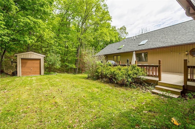 view of grassy yard featuring an outdoor structure and a wooden deck