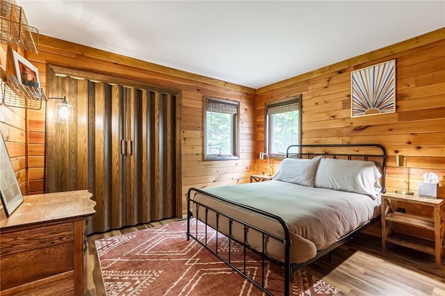 bedroom with wooden walls and wood finished floors