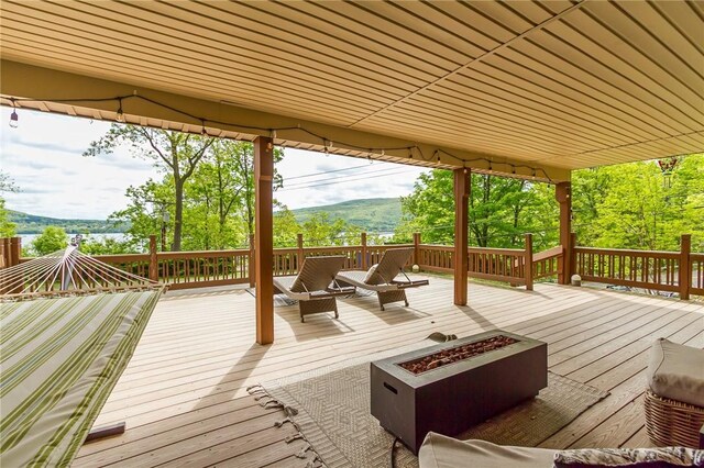 wooden deck featuring a fire pit and a mountain view