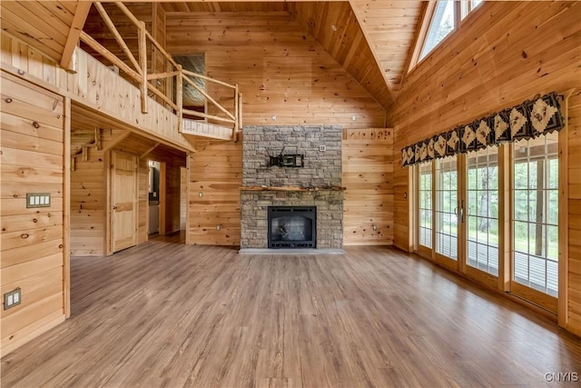 7278 Martin Dr, Leyden, NY 13309 - unfurnished living room with wood walls, high vaulted ceiling, wood finished floors, a fireplace, and wooden ceiling