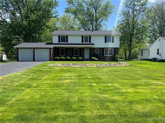 3385 Stony Point Rd, Grand Island, NY 14072 - view of front facade featuring a garage, asphalt driveway, brick siding, a front lawn, and central AC unit