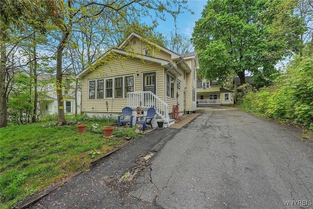 bungalow-style home featuring asphalt driveway
