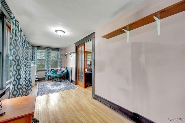 interior space with wood finished floors, baseboards, and french doors