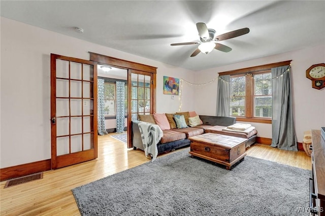 living area with wood finished floors, ceiling fan, and baseboards