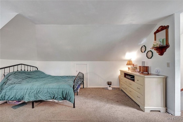 carpeted bedroom featuring lofted ceiling and baseboards