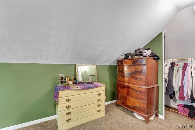 carpeted bedroom with vaulted ceiling and baseboards