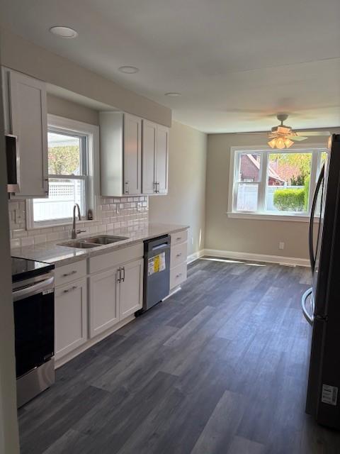 34 Sunnyside Dr, Elmira, NY 14905 - kitchen featuring dishwashing machine, a sink, stainless steel electric stove, freestanding refrigerator, and plenty of natural light