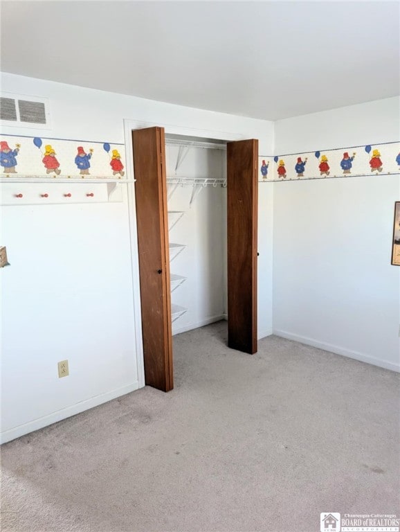 unfurnished bedroom featuring light colored carpet, baseboards, and a closet
