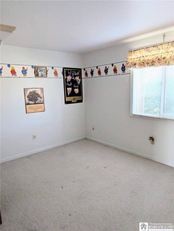 unfurnished room with carpet flooring and baseboards