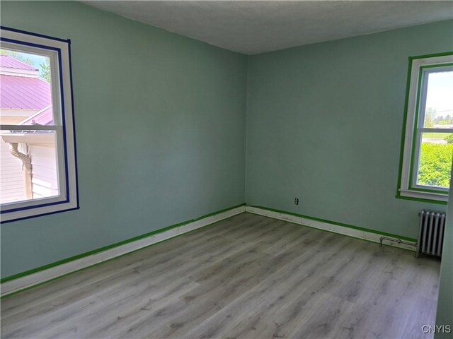 343 N Peterboro St, Lenox, NY 13032 - empty room featuring wood finished floors, plenty of natural light, radiator, and baseboards