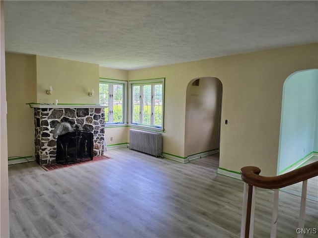 343 N Peterboro St, Lenox, NY 13032 - living area with radiator heating unit, arched walkways, a textured ceiling, and wood finished floors